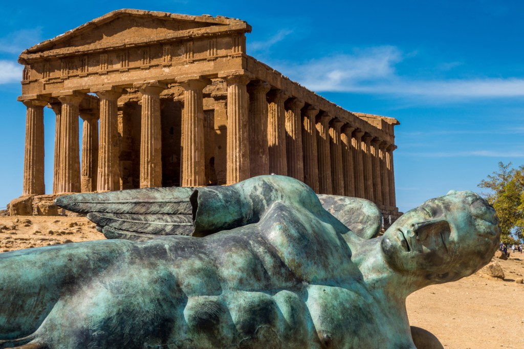 Ancient sculpture foregrounding the Temple of Concordia