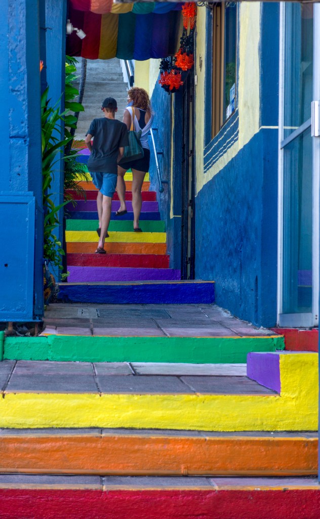 Mother and son climb the rainbow color stairs in gay district of Puerto Vallarta.
