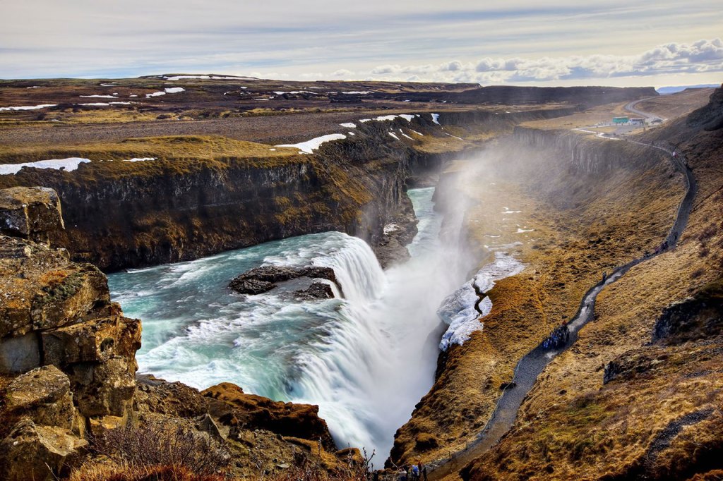 Aerial view of wide rocky canyon with dramatic waterfalls flowing into it