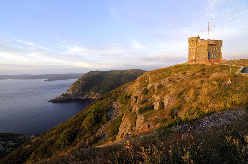 Image of stone building on tall cliffside hill overlooking the ocean