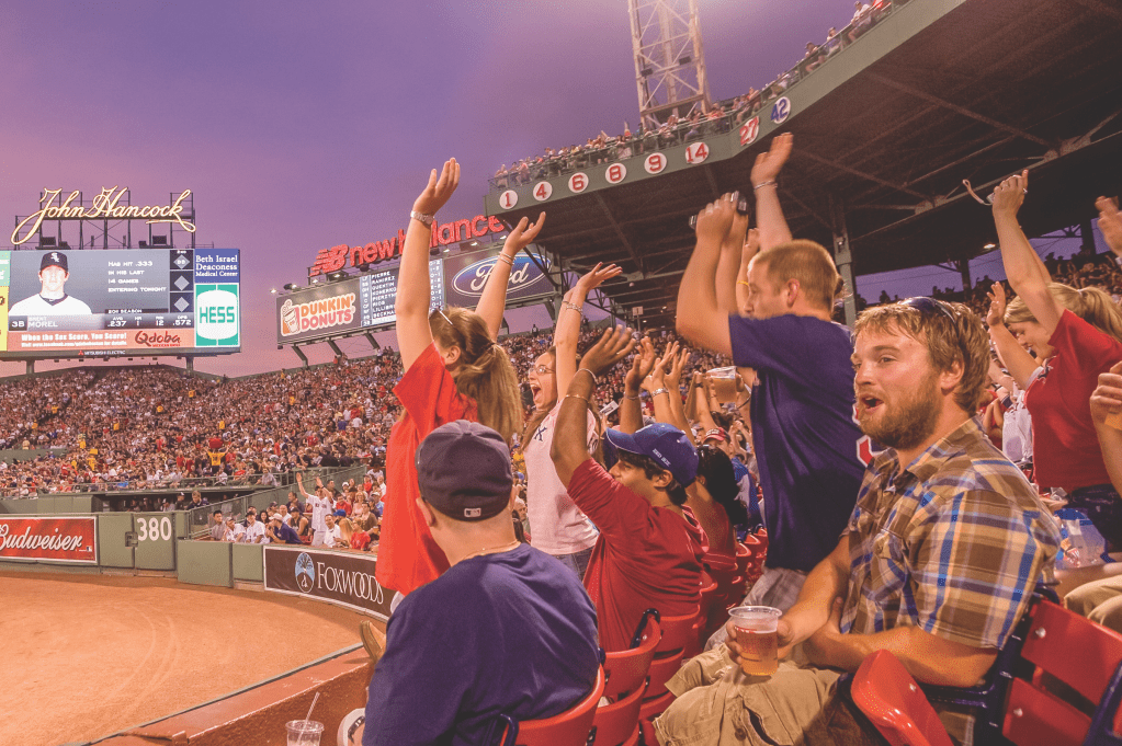Fans raise their hands and cheer on the Red Sox